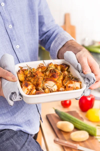 Hidangan panggang dengan paha ayam panas di tangan manusia. — Stok Foto