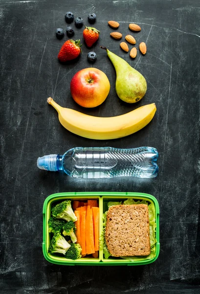 Skolan matlåda med smörgås, grönsaker, vatten och frukt — Stockfoto