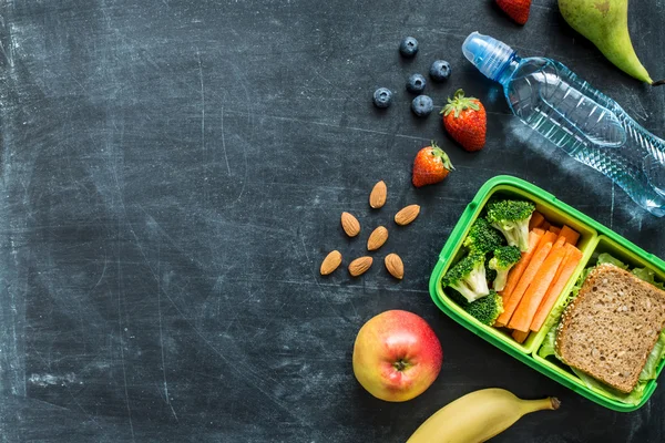 Skolan matlåda med smörgås, grönsaker, vatten och frukt — Stockfoto