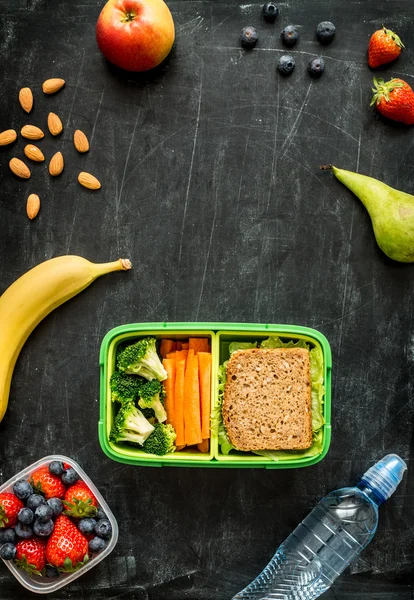 School lunch box with sandwich, vegetables, water and fruits — Stock Image School lunch box with sandwich, vegetables, water and fruits Royalty Free Stock Images