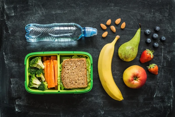 School lunch box with sandwich, vegetables, water and fruits — Stock Image School lunch box with sandwich, vegetables, water and fruits Stock Photo