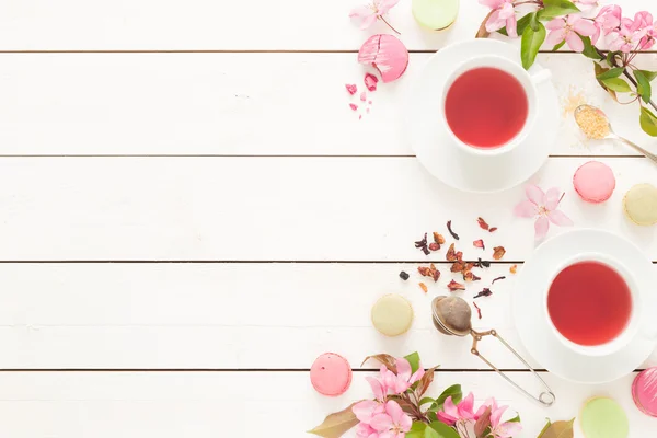 Chá frutado rosa e pastel bolos de macarons franceses em branco — Fotografia de Stock