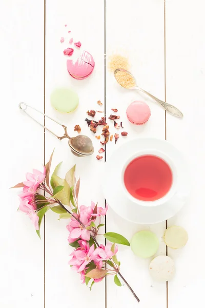 Té afrutado rosado y pasteles de macarrones franceses en blanco —  Fotos de Stock