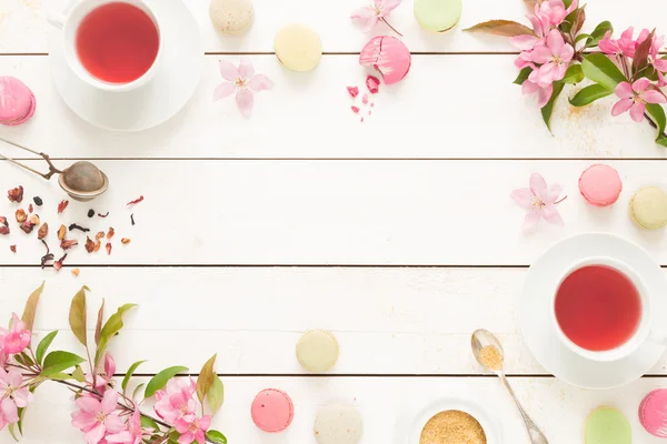 Gyümölcstea rózsaszín, és pasztell francia macarons sütemények, fehér — Stock Fotó