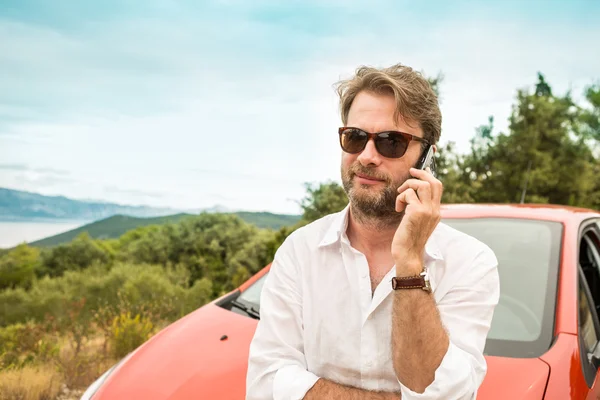 Mann (Tourist) vor einem Auto und telefoniert — Stockfoto