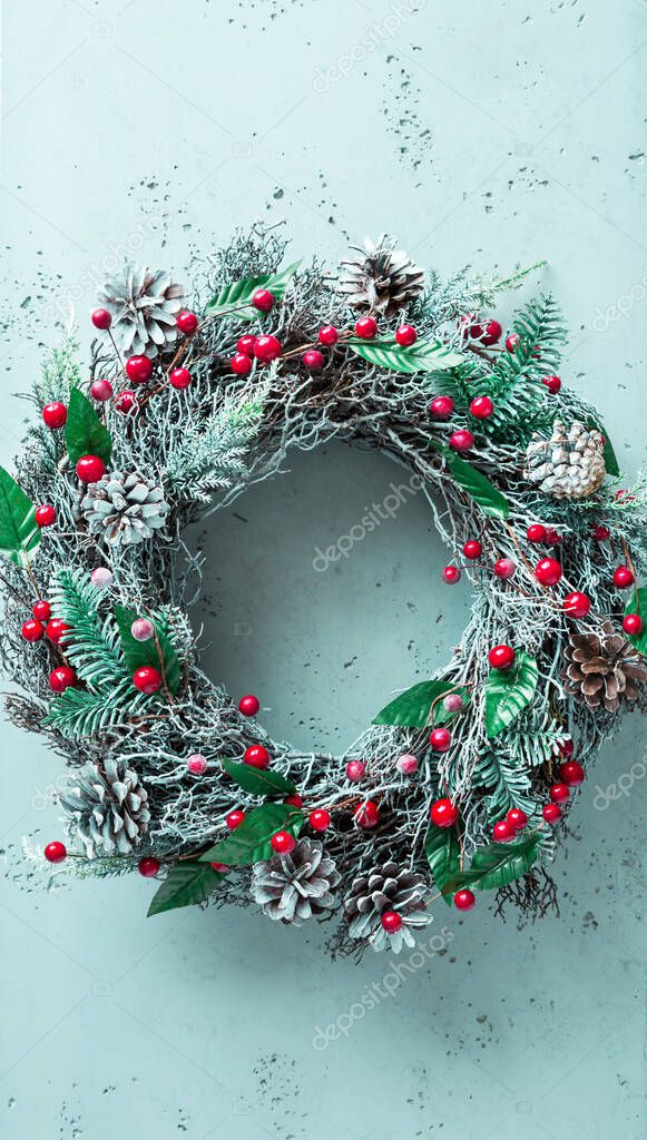Christmas wreath on pastel blue background. Horizontal layout with free copy (text) space. Winter holiday home decoration.