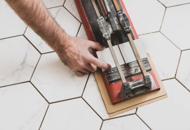 İç işleri çalışanı (tiler veya tamirci) elle kesme aleti kullanıyor. Banyo yenileme işi.. 