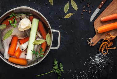 Preparing chicken stock with vegetables in a pot clipart