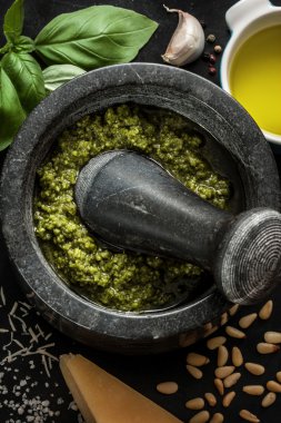 Green basil pesto - italian recipe ingredients on black