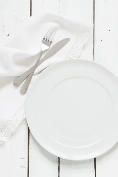 White table setting from above. Empty plate, cutlery, napkin on — 图库照片