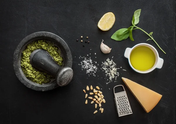 Pesto de albahaca verde - ingredientes de la receta italiana en pizarra negra —  Fotos de Stock