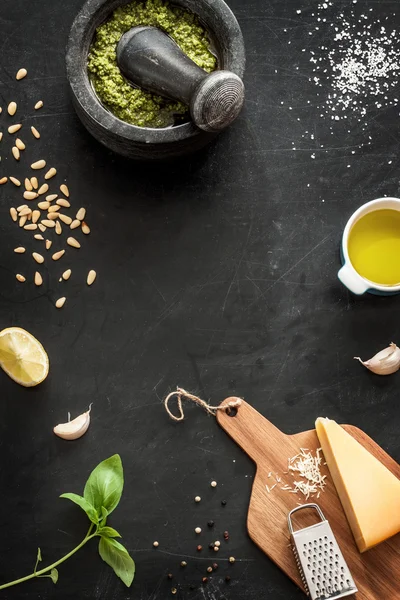 Green basil pesto - italian recipe ingredients on black chalkboad — ストック写真