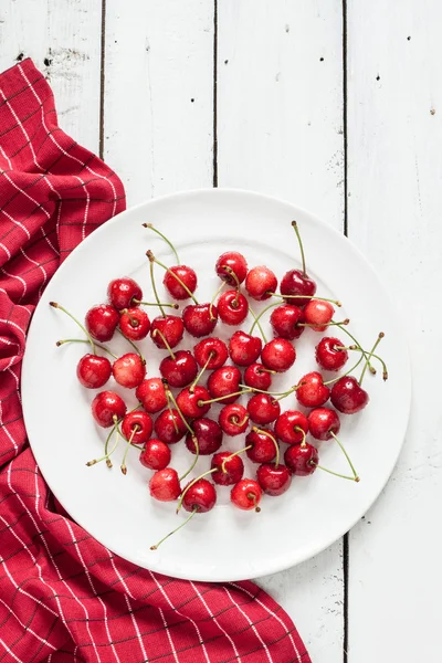 Fresh wet cherries on plate with red napkin