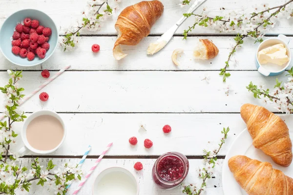 Romantique petit déjeuner français ou rural - cacao, lait, croissants, confiture, beurre et framboises — Photo