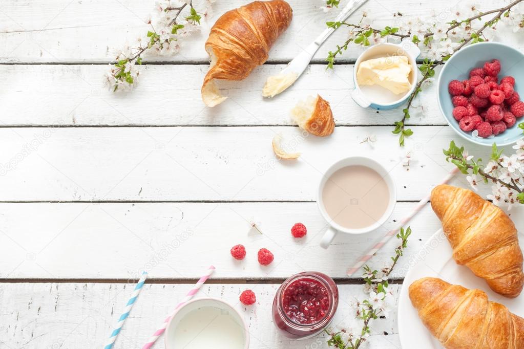 Romantic french or rural breakfast - cocoa, milk, croissants, jam, butter and raspberries