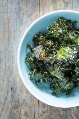 Kale chips with salt in pastel blue bowl