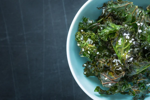 Kale chips with salt in pastel blue bowl