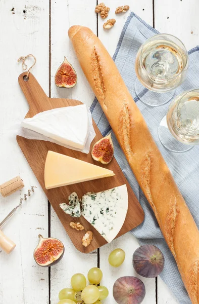 Different kinds of cheeses baguette and white wine