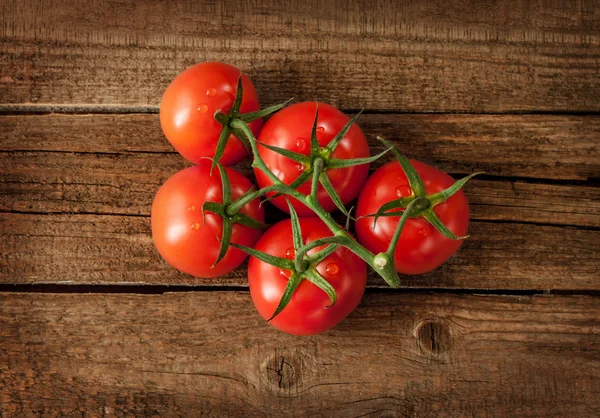 Tomato branch on vintage wooden table from above — Stok fotoğraf