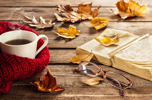 Hot coffee, vintage book, glasses and autumn leaves on wood — 스톡 사진
