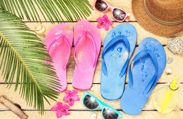 Praia, folhas de palmeira, areia, óculos de sol e chinelos — Fotografia de Stock