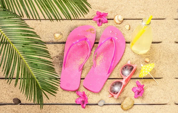 Beach, palm tree leaves, sand, sunglasses and flip flops — Stockfoto