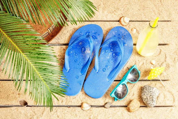 Beach, palm tree leaves, sand, sunglasses and flip flops — Stockfoto