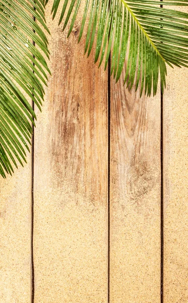 Palm tree leaves and sand on wood background — Φωτογραφία Αρχείου