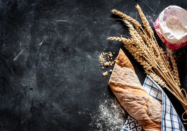 Baguete francesa, trigo e farinha em chalkboard preto — Fotografia de Stock