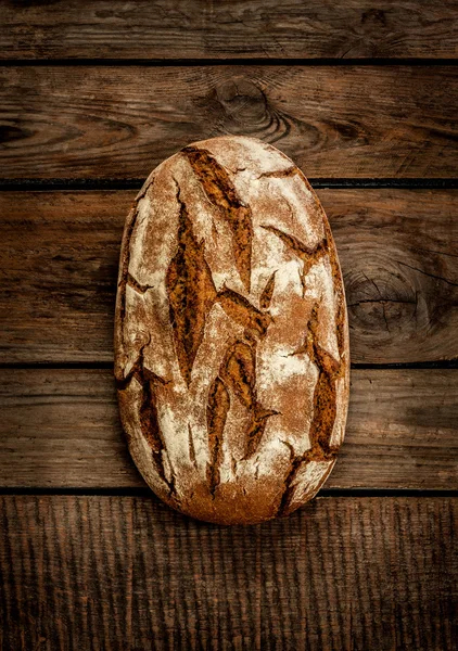 Χωριάτικο ψωμί σε μια παλαιά εκλεκτής ποιότητας planked τραπέζι από ξύλο — Φωτογραφία Αρχείου