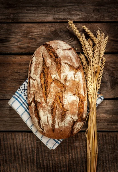 Pain rustique et blé sur une vieille table en bois — Photo