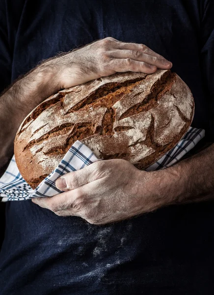 Rustik limpa bröd i mans händer — Stockfoto