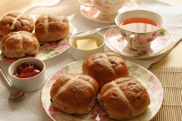 Tisch-Set mit heißen Kreuzbrötchen und Tee zu Ostern — Stockfoto