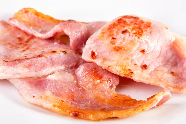 Fried bacon slices on a white plate. — Stock Photo, Image