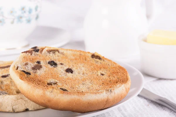 Te med en traditionell brittisk teacake russin, sultanrussin och — Stockfoto