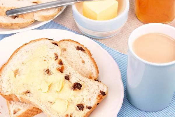 Pain de fruits tranché aux raisins secs et une tasse de thé au lait — Photo