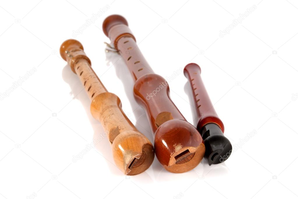 Three old battered wooden recorders isolated on white background