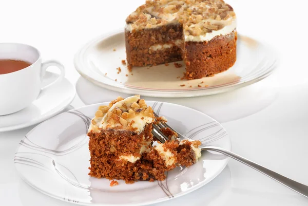 Rebanada de pastel de zanahoria servida en un plato con tenedor sobre una superficie blanca — Foto de Stock