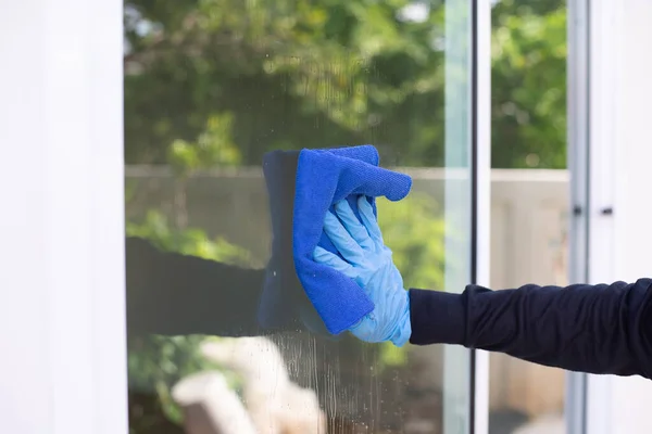 Close up of man hand cleaning window glass, Cleaning windows and doors at home.