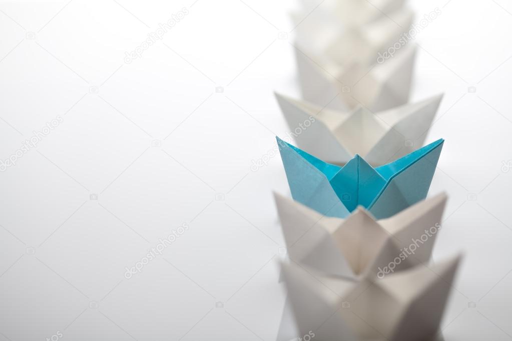 Leadership concept using blue paper ship