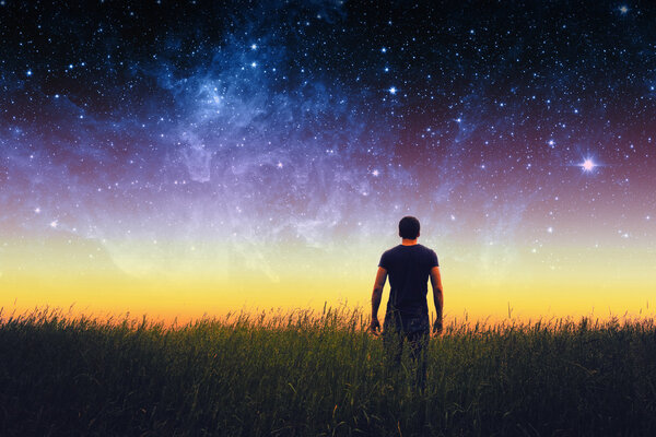 Silhouette of young man on stars sky. Elements of this image furnished by NASA.