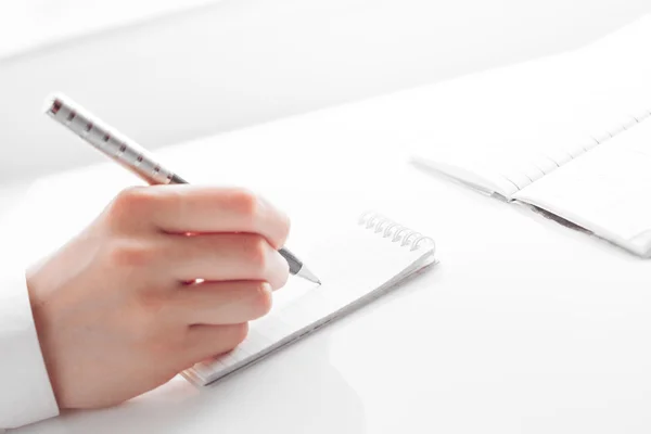 Γυναικείο χέρι γράφοντας καταχωρήσεις σε ένα σημειωματάριο — Φωτογραφία Αρχείου
