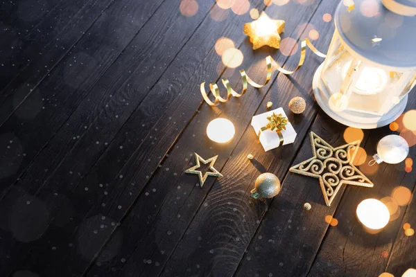 Weiße Weihnachtslaterne mit Kerzen und Golddekoration auf einem Holztisch — Stockfoto