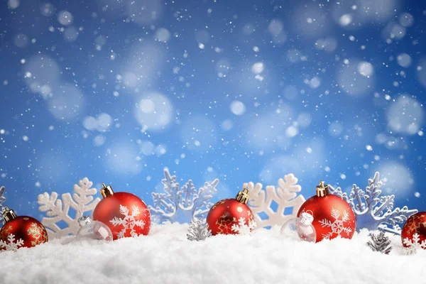 La fila de las bolas de Navidad y los copos de nieve que ponen en la nieve —  Fotos de Stock