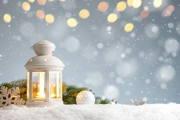 Lanterne blanche avec des décorations de Noël dans une dérive de neige sur fond bleu — Photo