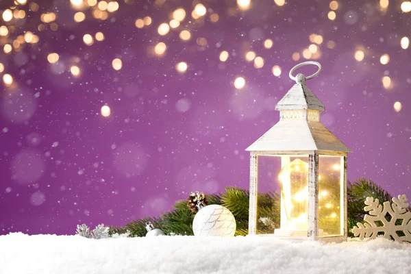 Волшебный фонарь с рождественскими игрушками на снегу на фиолетовом фоне — стоковое фото