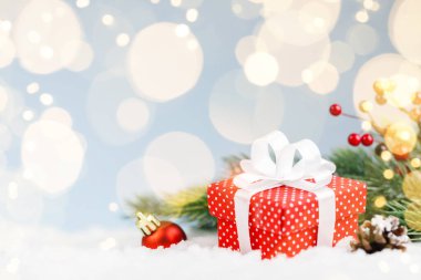 Ağaç dalları ve süslemeleri olan kırmızı Noel hediyesi.