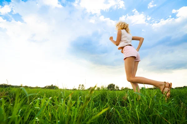 Jovencita corriendo por un camino rural al atardecer — Foto de Stock