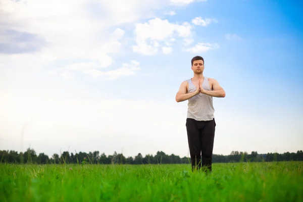 Jeune homme faisant du yoga dans le parc — Photo