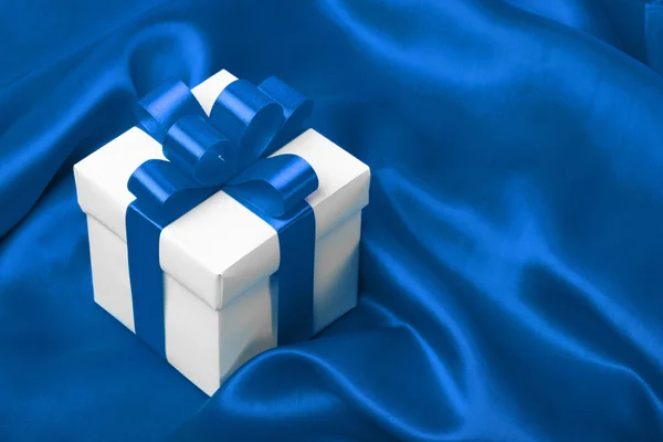 Geschenk auf blauem Satin Hintergrund — Stockfoto